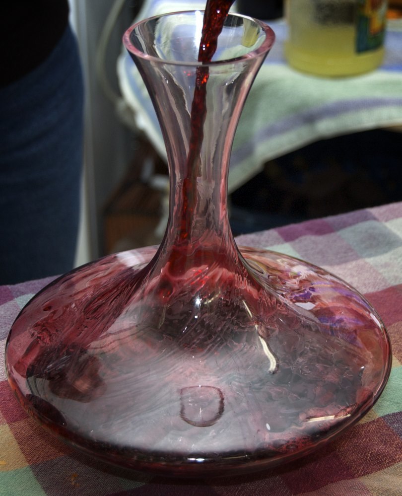 Crveno vino se dekantira u dekanter uz svetlo kako bi se odvojio sediment